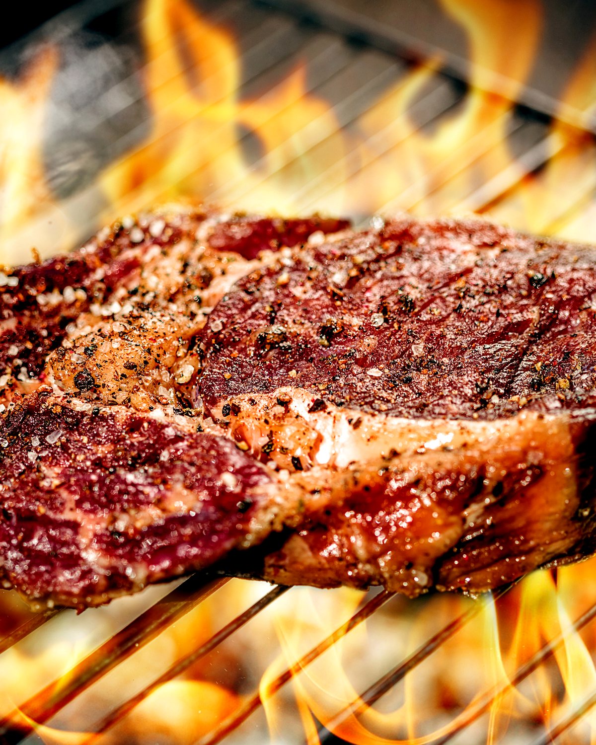 Entrecote boven de vlammen op de houtskoolgrill