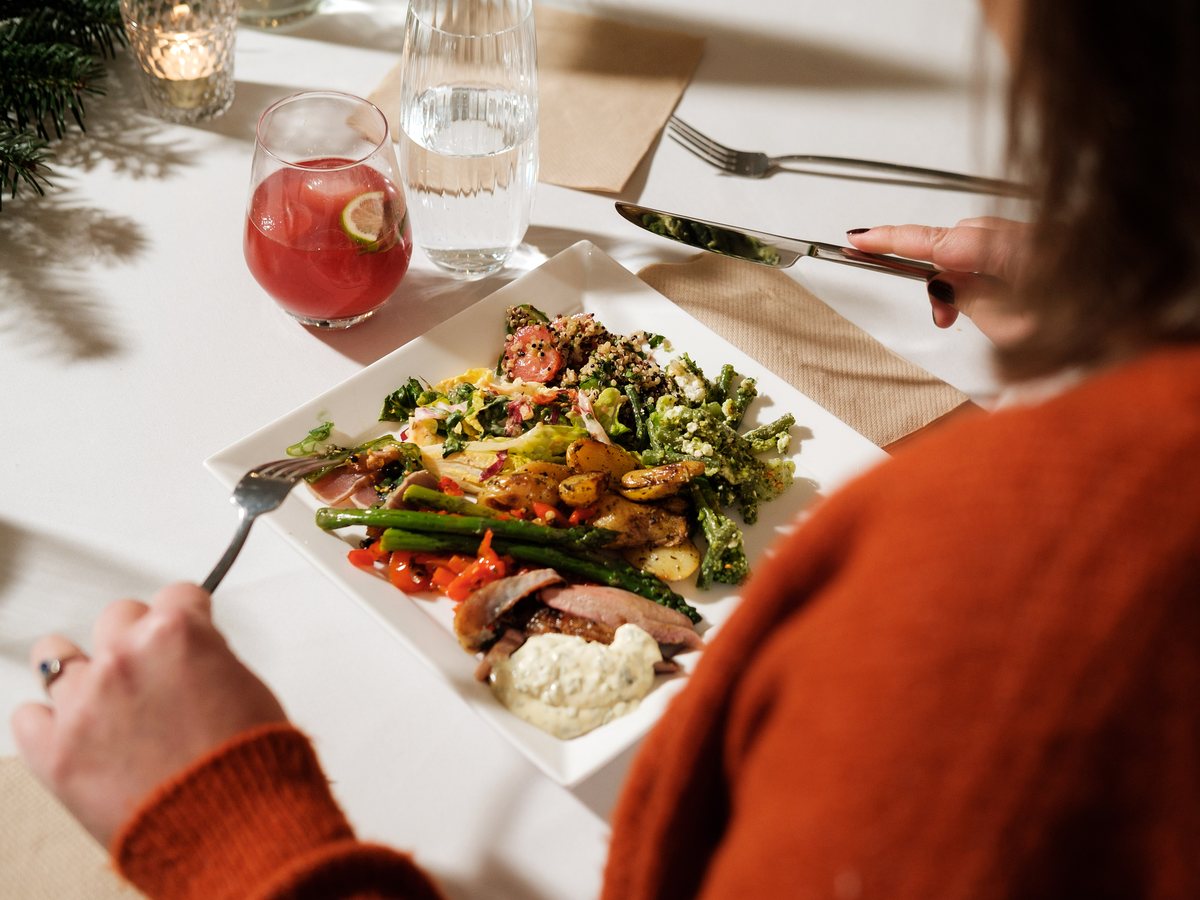 Een bord met vlees en groenten van de grill aan tafel